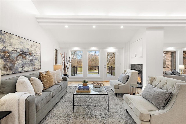 living room with vaulted ceiling with beams and light hardwood / wood-style flooring