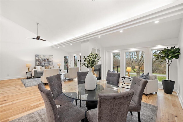 dining room with vaulted ceiling with beams, light hardwood / wood-style floors, and ceiling fan