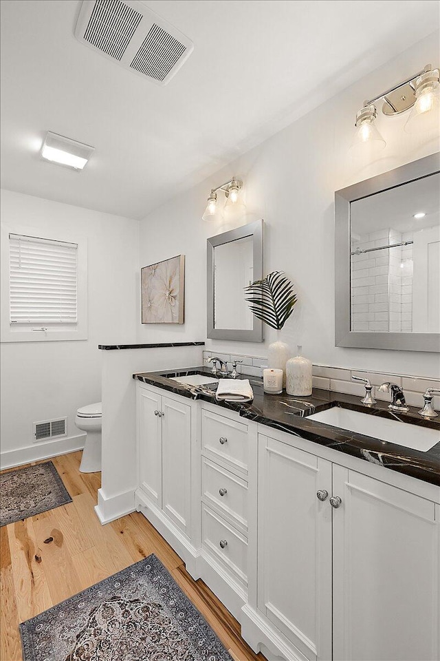 bathroom with hardwood / wood-style floors, vanity, and toilet