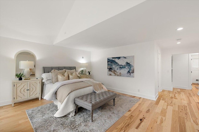 bedroom featuring light wood-type flooring and vaulted ceiling