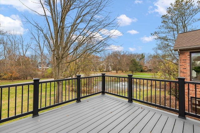 wooden terrace featuring a water view and a yard