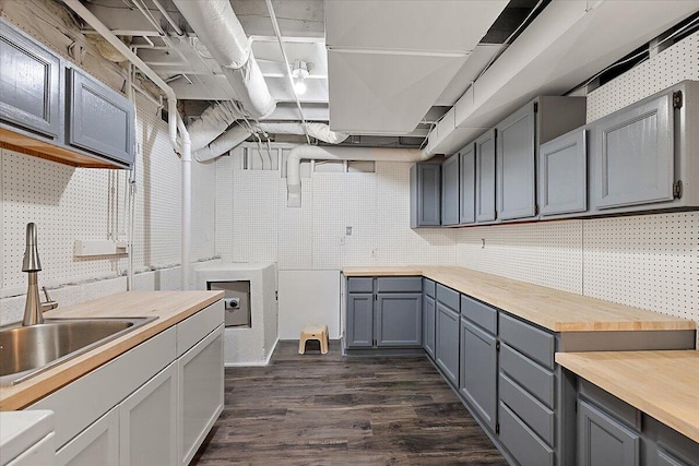 kitchen with butcher block counters, gray cabinetry, sink, dark hardwood / wood-style flooring, and decorative backsplash