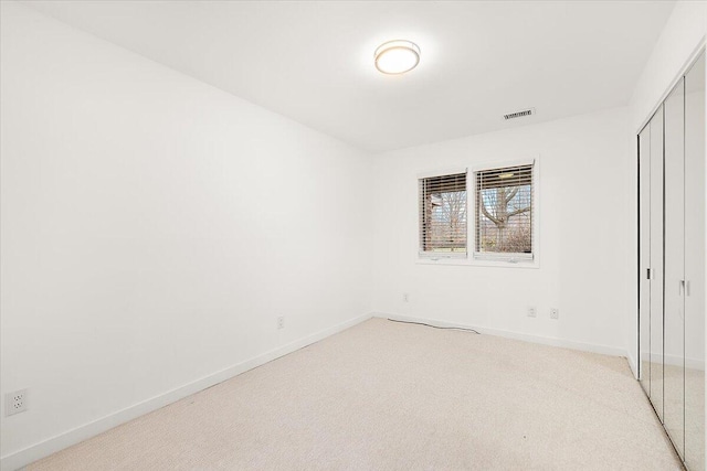 unfurnished bedroom with a closet and light colored carpet