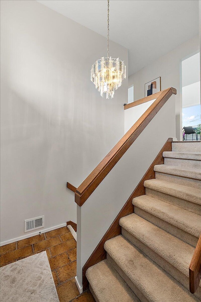 stairway with a notable chandelier