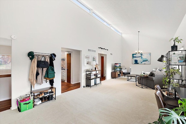 carpeted living room featuring a high ceiling and a notable chandelier