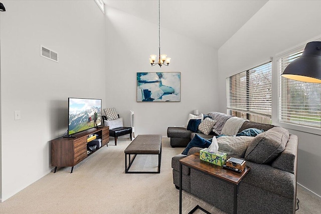 carpeted living room featuring high vaulted ceiling and a chandelier