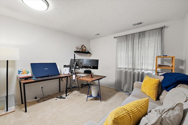 home office with a textured ceiling and light colored carpet