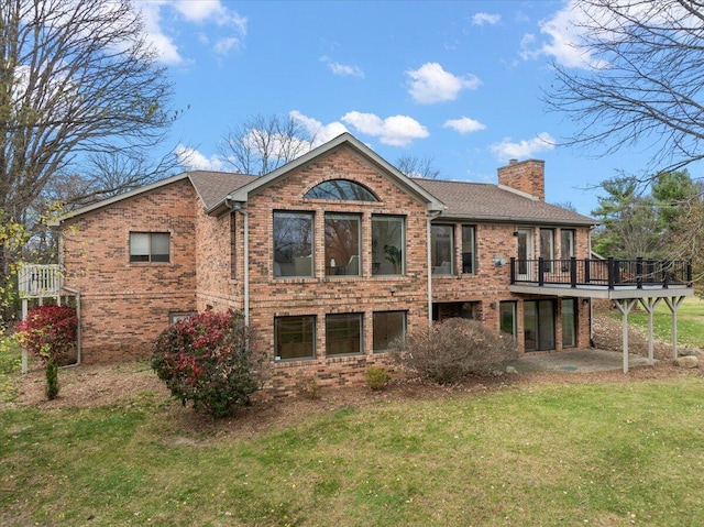 rear view of house with a deck and a yard