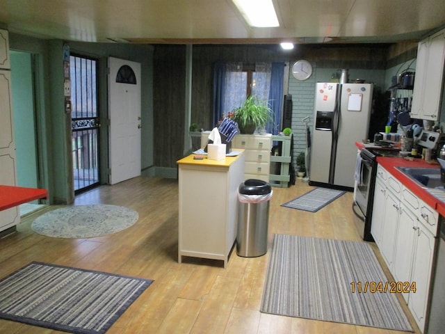 kitchen with white cabinetry, light hardwood / wood-style floors, and stainless steel appliances