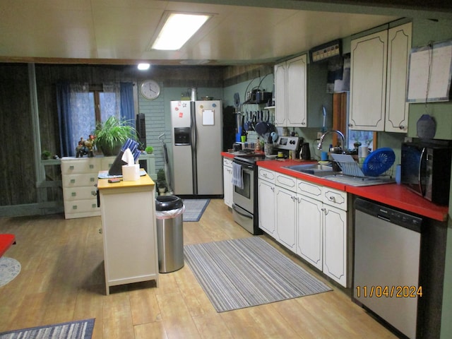 kitchen featuring light hardwood / wood-style floors, butcher block countertops, sink, white cabinetry, and appliances with stainless steel finishes