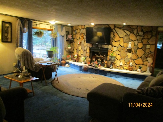 living room featuring a textured ceiling and a stone fireplace