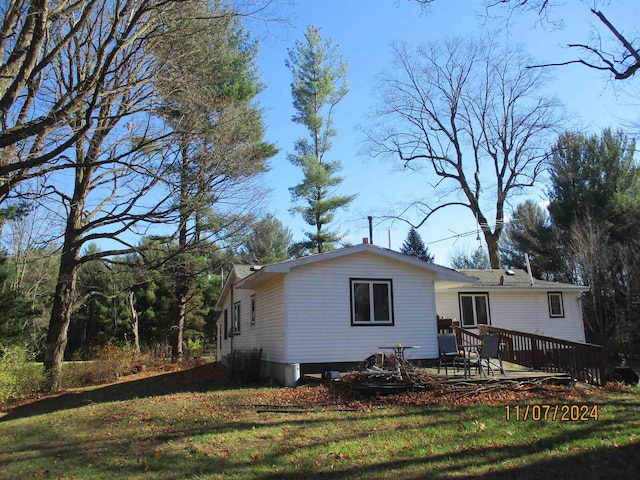 rear view of property with a deck and a lawn