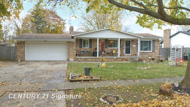 527 Leland St, Flushing, MI 48433 - view of front of house with covered porch, a garage, concrete driveway, and brick siding