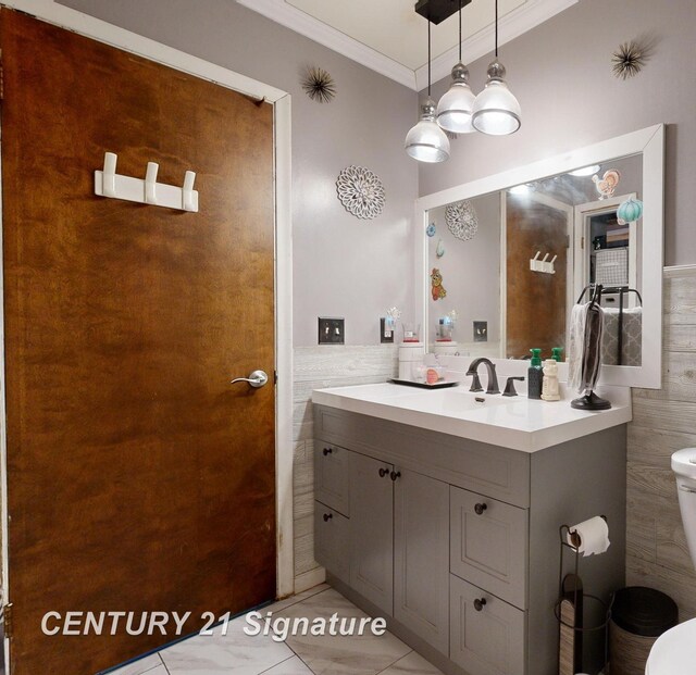 527 Leland St, Flushing, MI 48433 - bathroom featuring tile walls, vanity, toilet, ornamental molding, and wainscoting