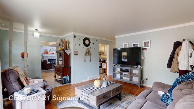 527 Leland St, Flushing, MI 48433 - living room with a fireplace, wood finished floors, crown molding, and baseboards