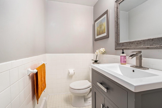 bathroom featuring tile patterned floors, vanity, toilet, and tile walls