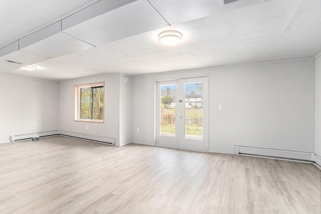 unfurnished room featuring baseboard heating, a wealth of natural light, and light hardwood / wood-style flooring