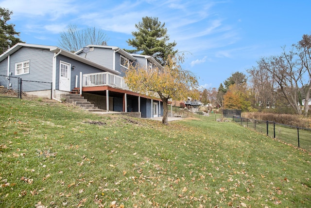 rear view of property featuring a lawn and a wooden deck