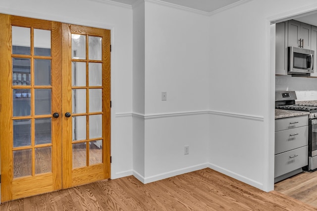 unfurnished dining area featuring ornamental molding, light hardwood / wood-style flooring, and french doors