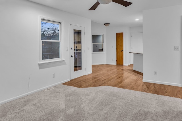 carpeted spare room featuring ceiling fan