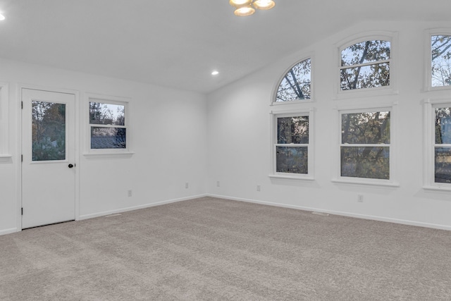 spare room featuring high vaulted ceiling and light colored carpet