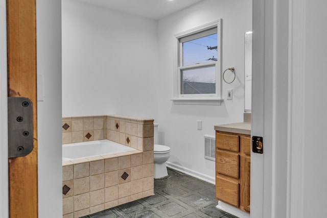 bathroom with vanity, a relaxing tiled tub, and toilet