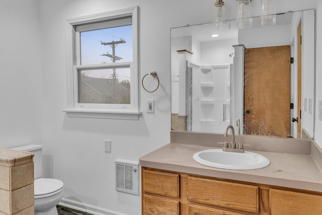 bathroom featuring a shower, vanity, and toilet