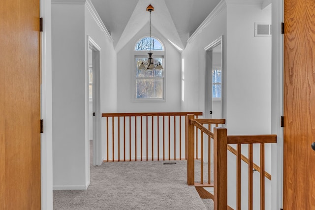 corridor featuring carpet floors, vaulted ceiling, crown molding, and a notable chandelier