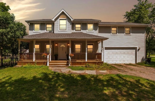 view of front of property with a lawn, a porch, and a garage