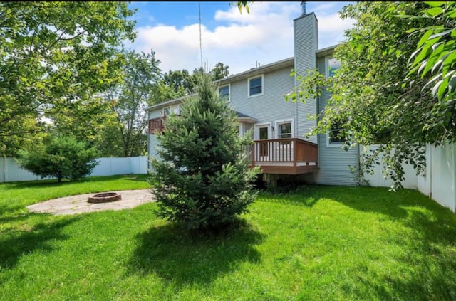 view of yard with a wooden deck and an outdoor fire pit