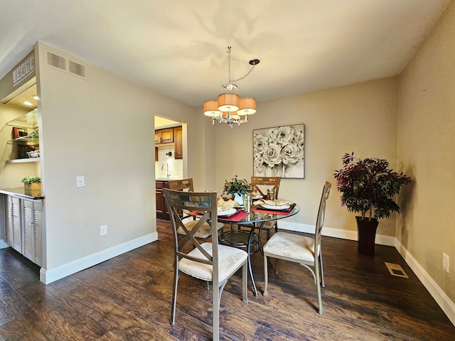 dining area featuring dark wood-type flooring and a notable chandelier