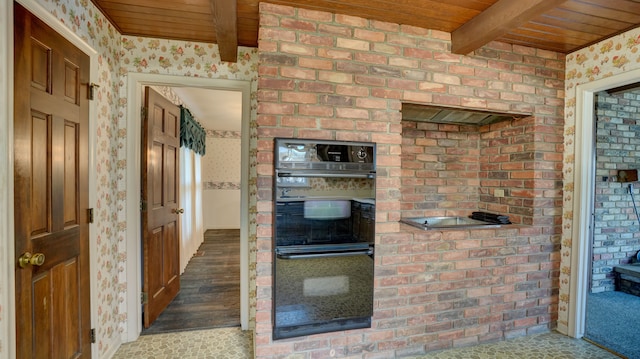 kitchen with beamed ceiling, double oven, and wooden ceiling