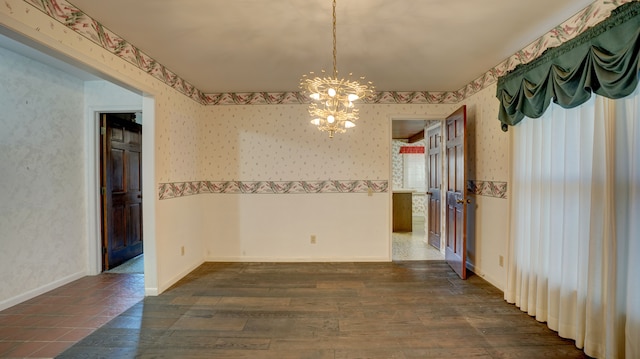 empty room featuring dark hardwood / wood-style flooring and a chandelier