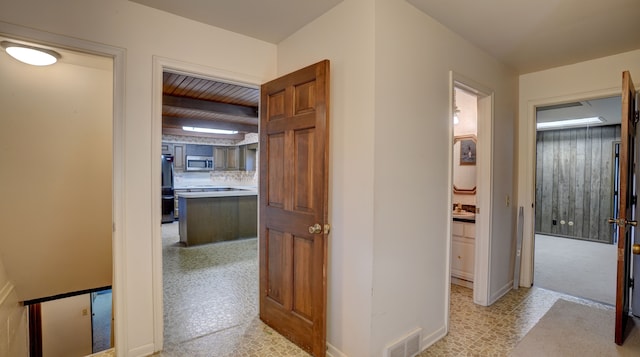 hallway with beam ceiling and sink