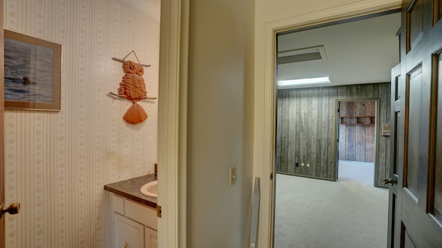 bathroom featuring vanity and wooden walls