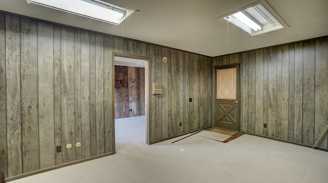 spare room with wood walls and light colored carpet