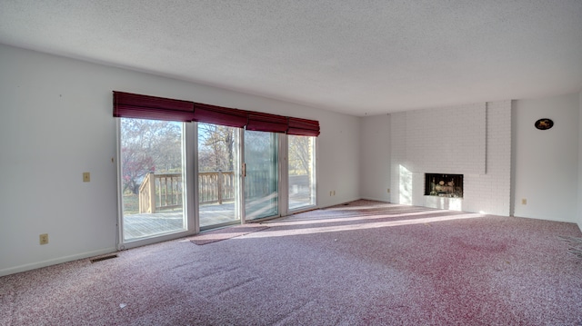 unfurnished living room with carpet flooring, a fireplace, and a textured ceiling