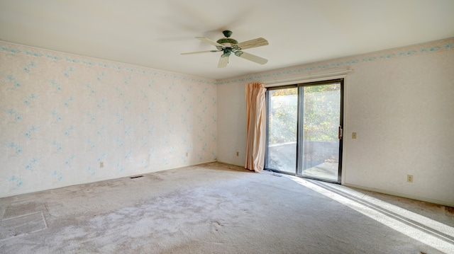 spare room featuring ceiling fan and carpet floors