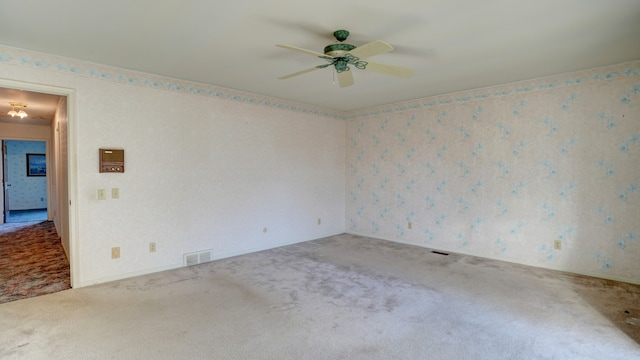 carpeted spare room featuring ceiling fan