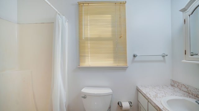 bathroom with vanity, toilet, and walk in shower