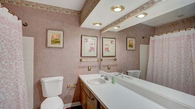 bathroom featuring a shower with shower curtain, vanity, and toilet