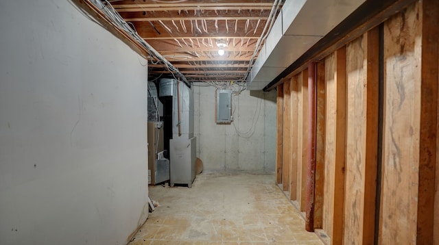 basement featuring electric panel and heating unit