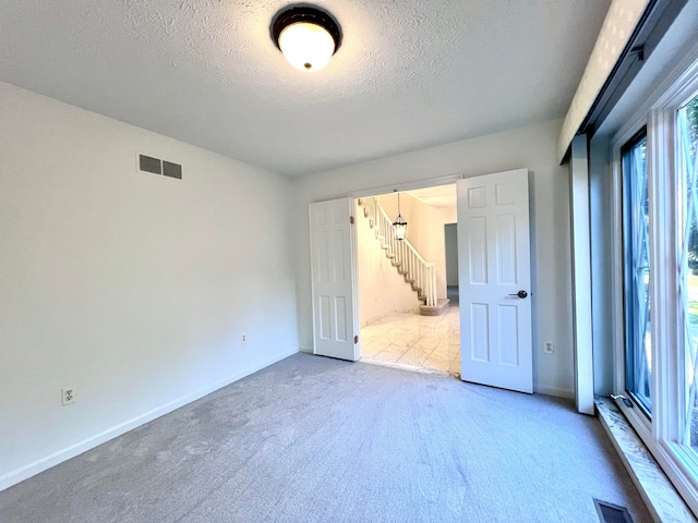 empty room with carpet and a textured ceiling