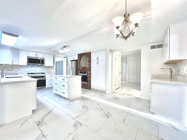 kitchen with pendant lighting, sink, beam ceiling, white cabinetry, and stainless steel appliances