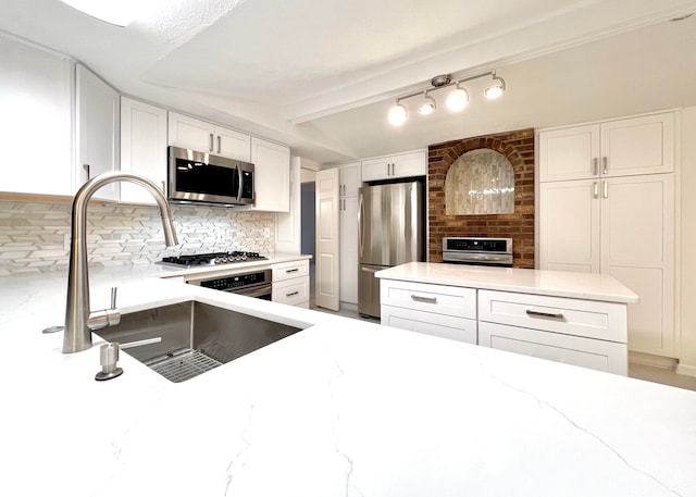 kitchen featuring stainless steel appliances, tasteful backsplash, light stone counters, beamed ceiling, and white cabinets