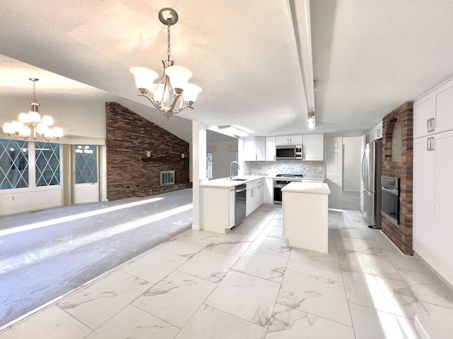 kitchen featuring white cabinets, brick wall, a fireplace, and appliances with stainless steel finishes