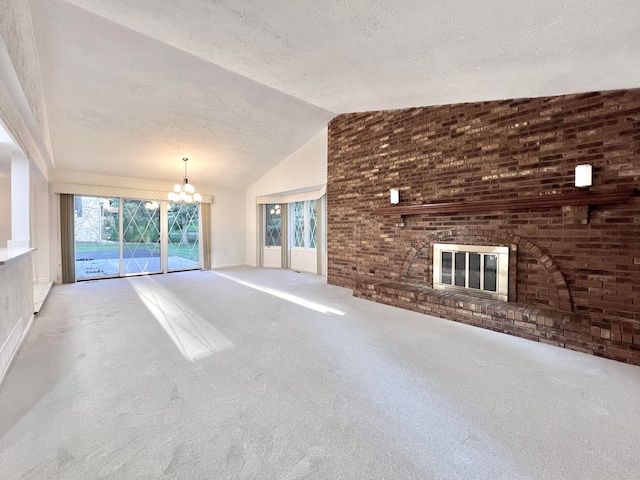 unfurnished living room featuring lofted ceiling, a brick fireplace, carpet flooring, a notable chandelier, and brick wall