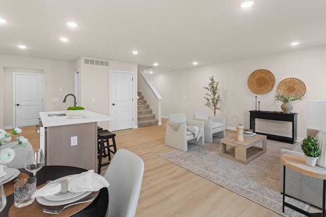 living room with sink and light hardwood / wood-style floors