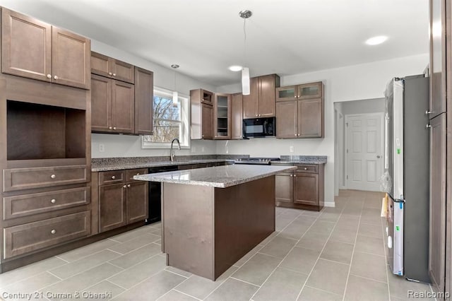 kitchen featuring light stone countertops, black appliances, pendant lighting, a kitchen island, and light tile patterned flooring