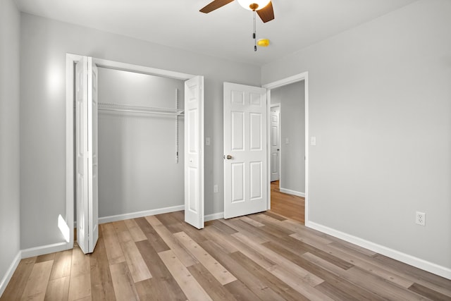 unfurnished bedroom featuring ceiling fan, a closet, and light hardwood / wood-style flooring